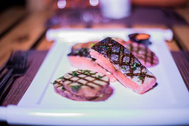 Izgara patates ve domatesli ızgara somon filetosu.