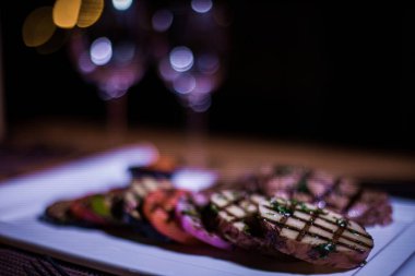 Kızarmış patates, domates ve soğanlı bir tabak et.