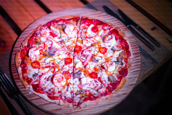 Tahta bir masada taze deniz ürünleri pizzası.
