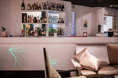 Restoran barının rafında farklı bir alkol şişesi var.