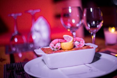 Masadaki parlak tencerede deniz ürünleri lazanyası.