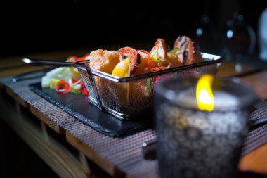 Yanında küçük bir salata porsiyonu olan metal bir kasede tavuk külçeleri.