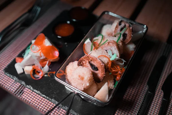 Yanında küçük bir salata porsiyonu olan metal bir kasede tavuk külçeleri.