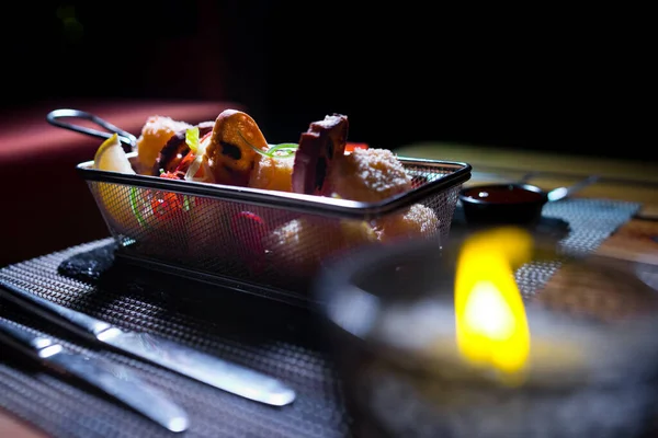 Yanında küçük bir salata porsiyonu olan metal bir kasede tavuk külçeleri.