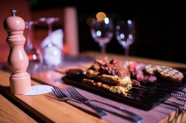 Izgara domates, patates ve soğanlı bir tabak tavuk ve biftek. 