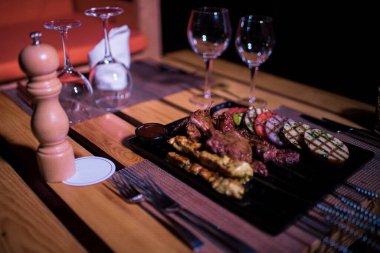 Izgara domates, patates ve soğanlı bir tabak tavuk ve biftek. 