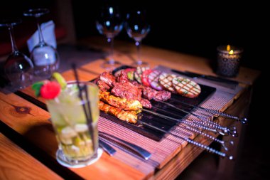 Izgara domates, patates ve soğanlı bir tabak tavuk ve biftek. 