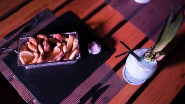 Yanında soğuk bir kokteyl olan küçük bir soğan halkası.