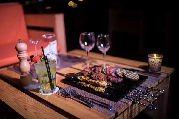 Izgara domates, patates ve soğanlı bir tabak tavuk ve biftek. 