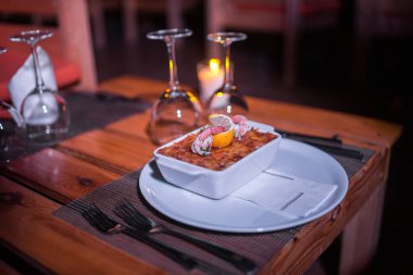 Masadaki parlak tencerede deniz ürünleri lazanyası.