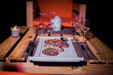 Bir tabak ızgara tavuk göğsü. Izgara patates, domates ve soğan.