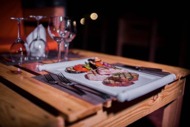 Bir tabak ızgara tavuk göğsü. Izgara patates, domates ve soğan.