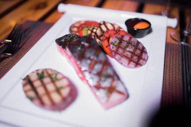 Izgara patates ve domatesli ızgara somon filetosu.