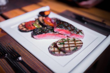 Izgara patates ve domatesli ızgara somon filetosu.