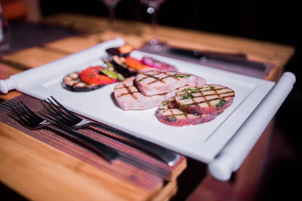 Bir tabak ızgara tavuk göğsü. Izgara patates, domates ve soğan.