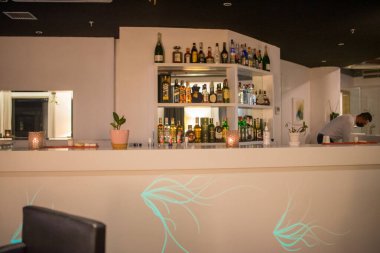 Restoran barının rafında farklı bir alkol şişesi var.