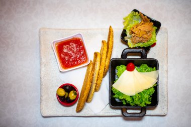 Kızarmış ekmek dilimleri ve yanında küçük marul salatası.