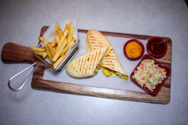 Patates kızartması ve küçük bir salata kasesiyle iki porsiyon dilimlenmiş Panini sandviçi.