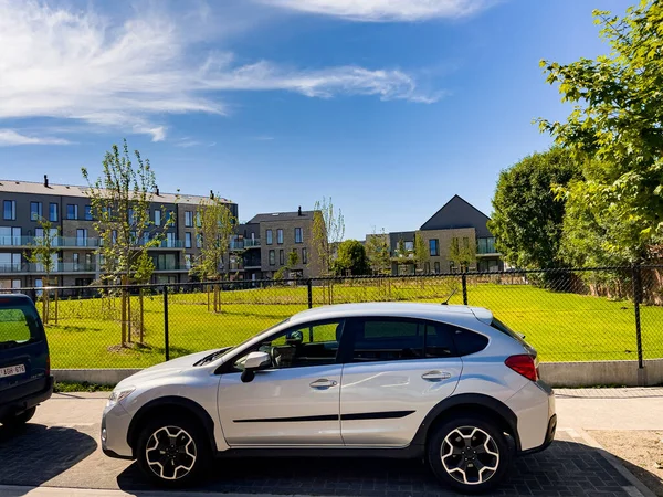 Bruxelles 'de yeşil bahçesi olan bir binanın yakınına birkaç araba park etmiş.