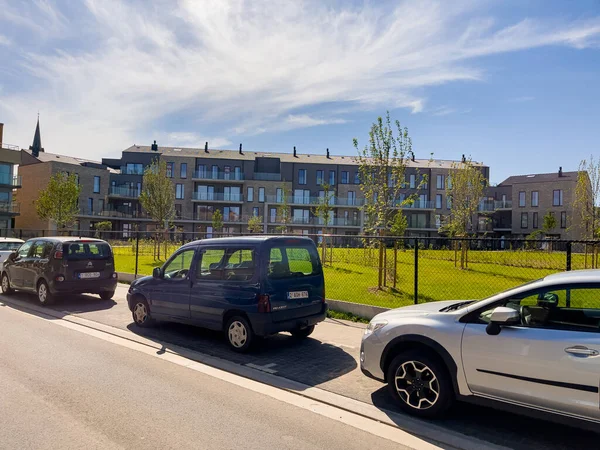 Bruxelles 'de yeşil bahçesi olan bir binanın yakınına birkaç araba park etmiş.