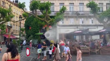 Bruxelles 'de sıcak bir günde sprey ve dere makinesiyle oynayan çok az çocuk var.