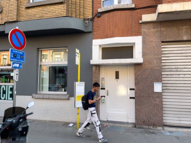 Bruxelles 'de bir eczanenin önünde yürüyen genç adam.