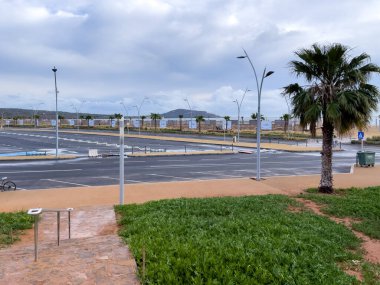 Arka planda gündoğumu gökyüzü olan boş bir otopark