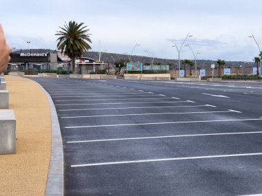 Arka planda gündoğumu gökyüzü olan boş bir otopark