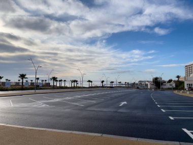 Arka planda gündoğumu gökyüzü olan boş bir otopark