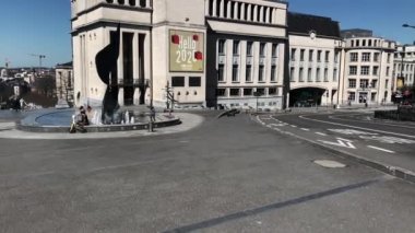 Babası ve oğlu Bruxelles 'de bir çeşmenin etrafında oturuyorlar.