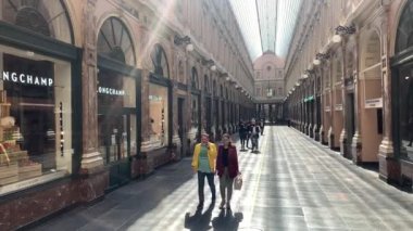 People with face masks walking through the Saint-Hubert gallery