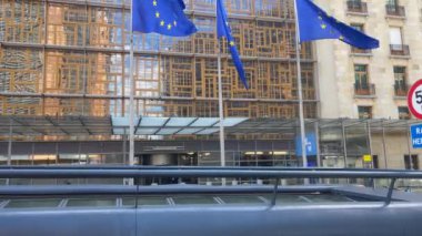 Dışarıda dalgalanan AB bayraklarının yanından geçen araba