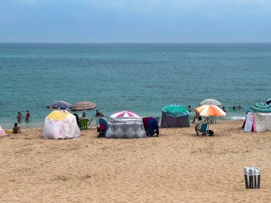 Bir grup insan sahilde yaz tatilinin tadını çıkarıyor.