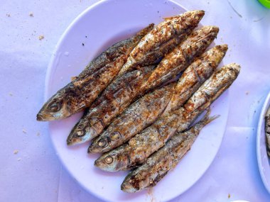 Beyaz bir tabakta ızgara sardalya.