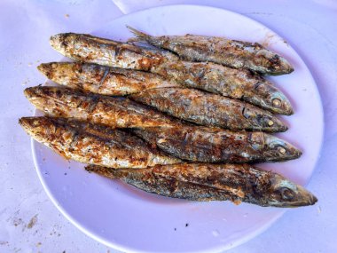 Beyaz bir tabakta ızgara sardalya.