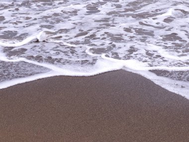 A gentle sea wave on a sandy beach