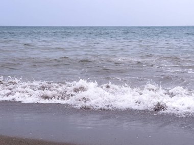 A gentle sea wave on a sandy beach