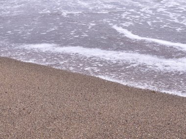 A gentle sea wave on a sandy beach