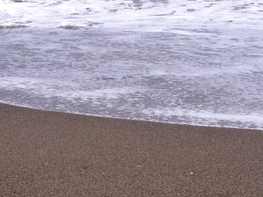 A gentle sea wave on a sandy beach