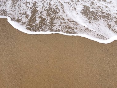 A gentle sea wave on a sandy beach