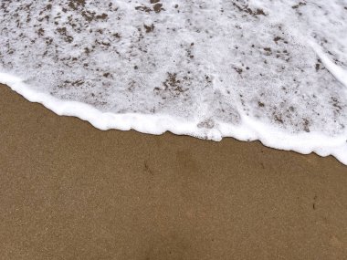 A gentle sea wave on a sandy beach