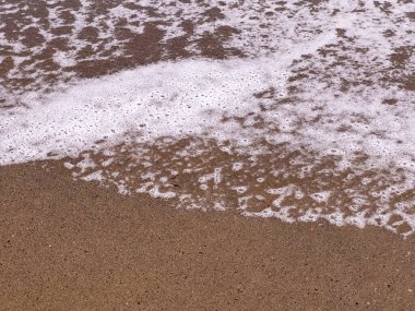 A gentle sea wave on a sandy beach