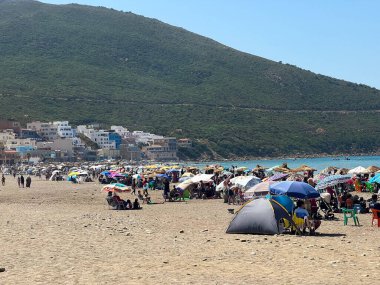 İnsanlar sahilde yaz tatilinin tadını çıkarıyorlar.