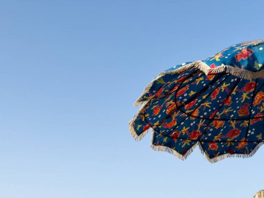 Textile parasol open with blue sky in the background