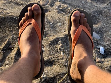 Male leg resting on a sandy beach