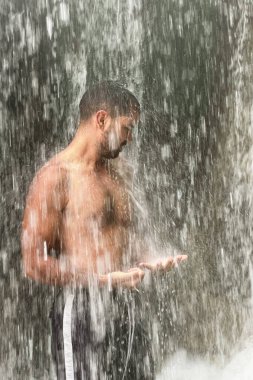 Fas 'ta şelalenin altında duran bir adam.