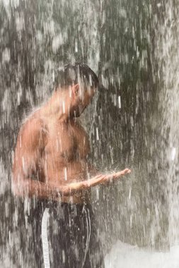 Fas 'ta şelalenin altında duran bir adam.