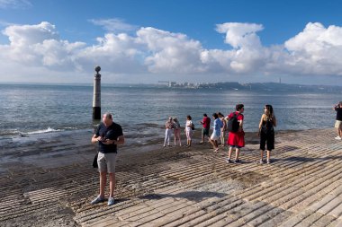 Lizbon 'da bir tekne rampasında duran insanlar.
