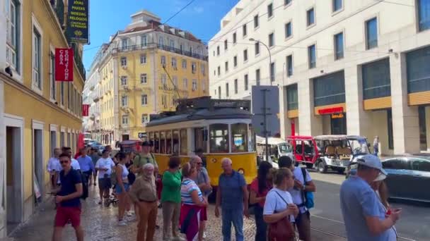 Lizbon Sokaklarında Bir Grup Turistin Yanından Geçen Retro Tramvay — Stok video