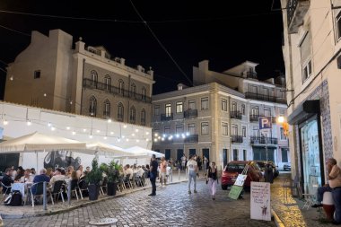 Geceleyin Lizbon caddesinde yürüyen bir kalabalık.